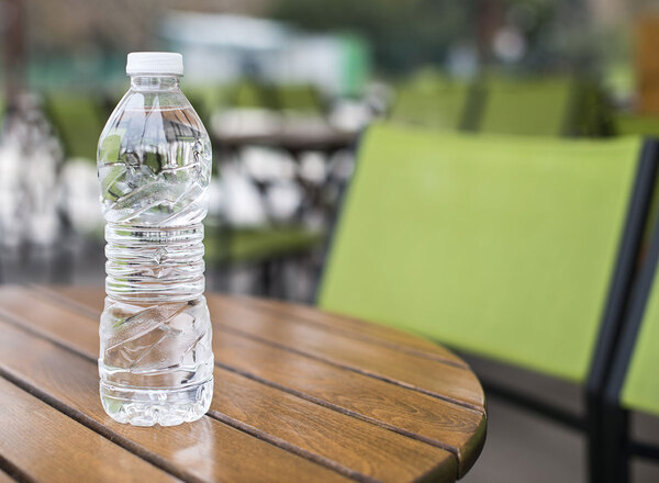 Botella de agua transparente sobre una mesa clara